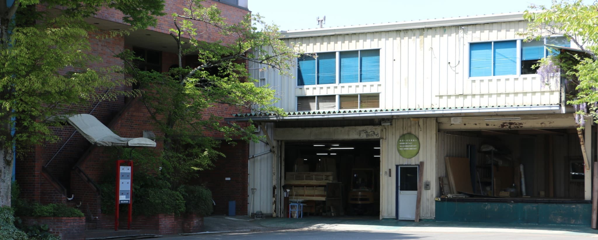 緑に囲まれた高橋工芸の工場外観